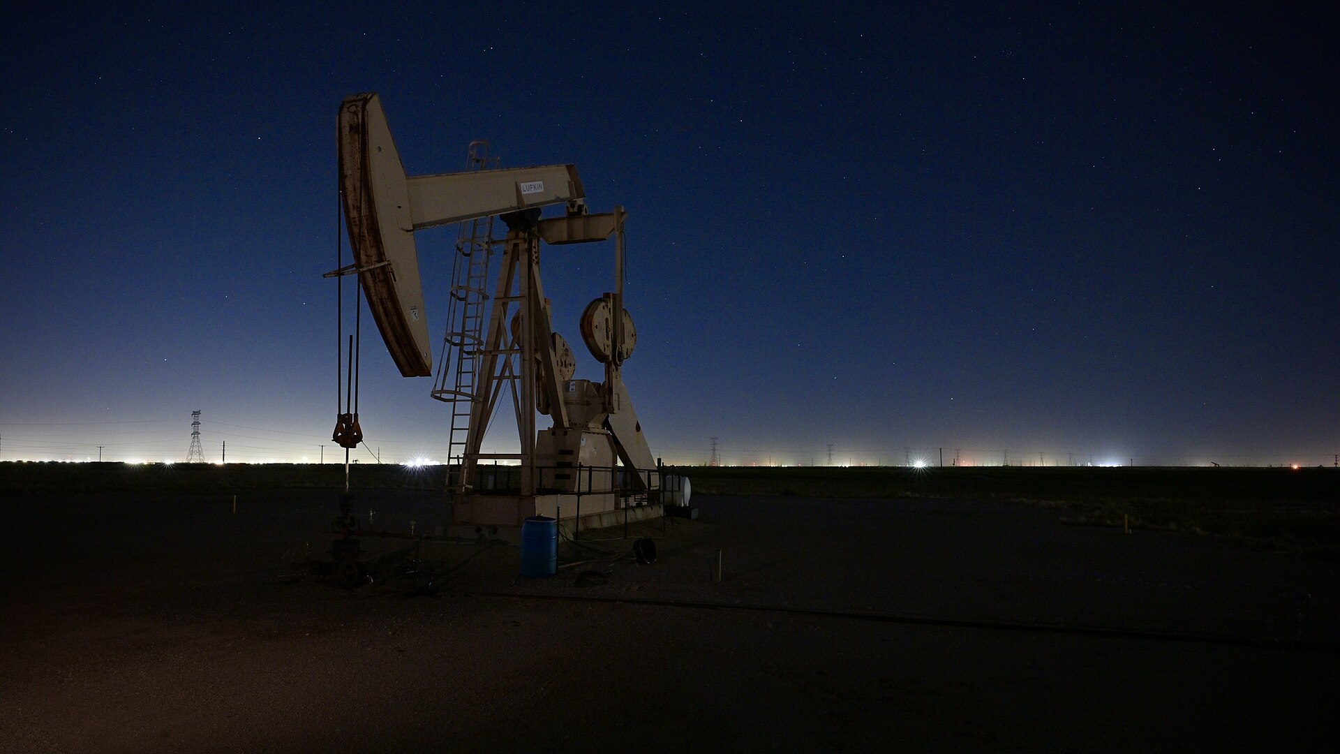 An oil pumpjack in West Texas at night, its head shaped like a horse's head