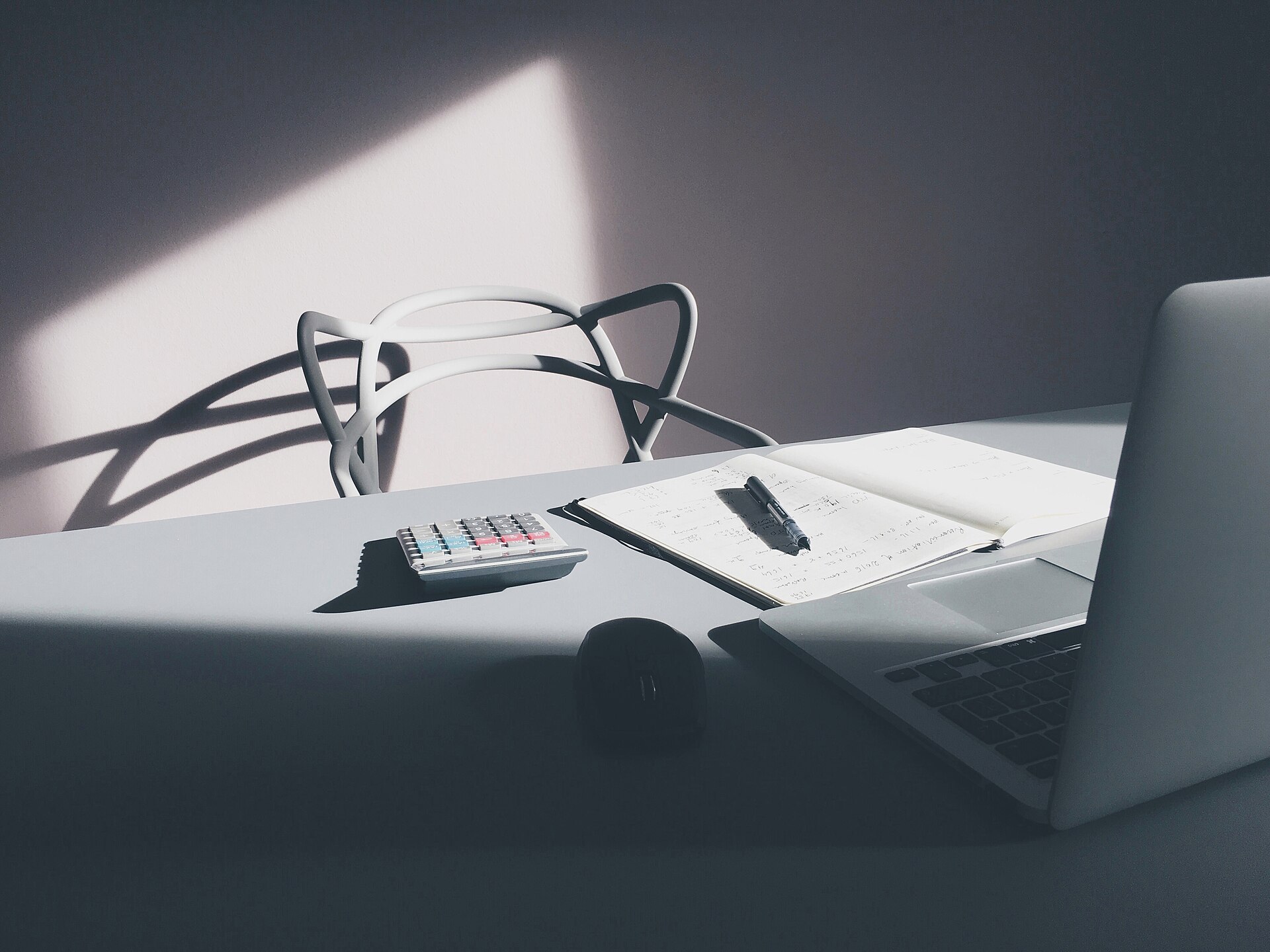 A desk with a laptop and a calculator