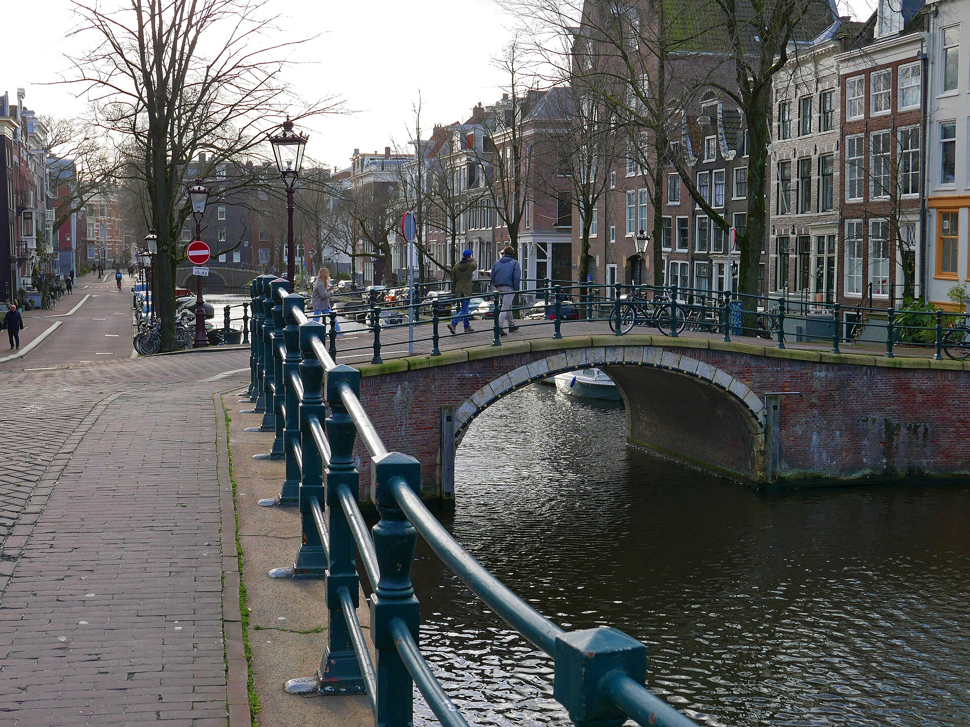 Canal in central Amsterdam with an old brick bridge over the Reguliersgracht and canal house facades